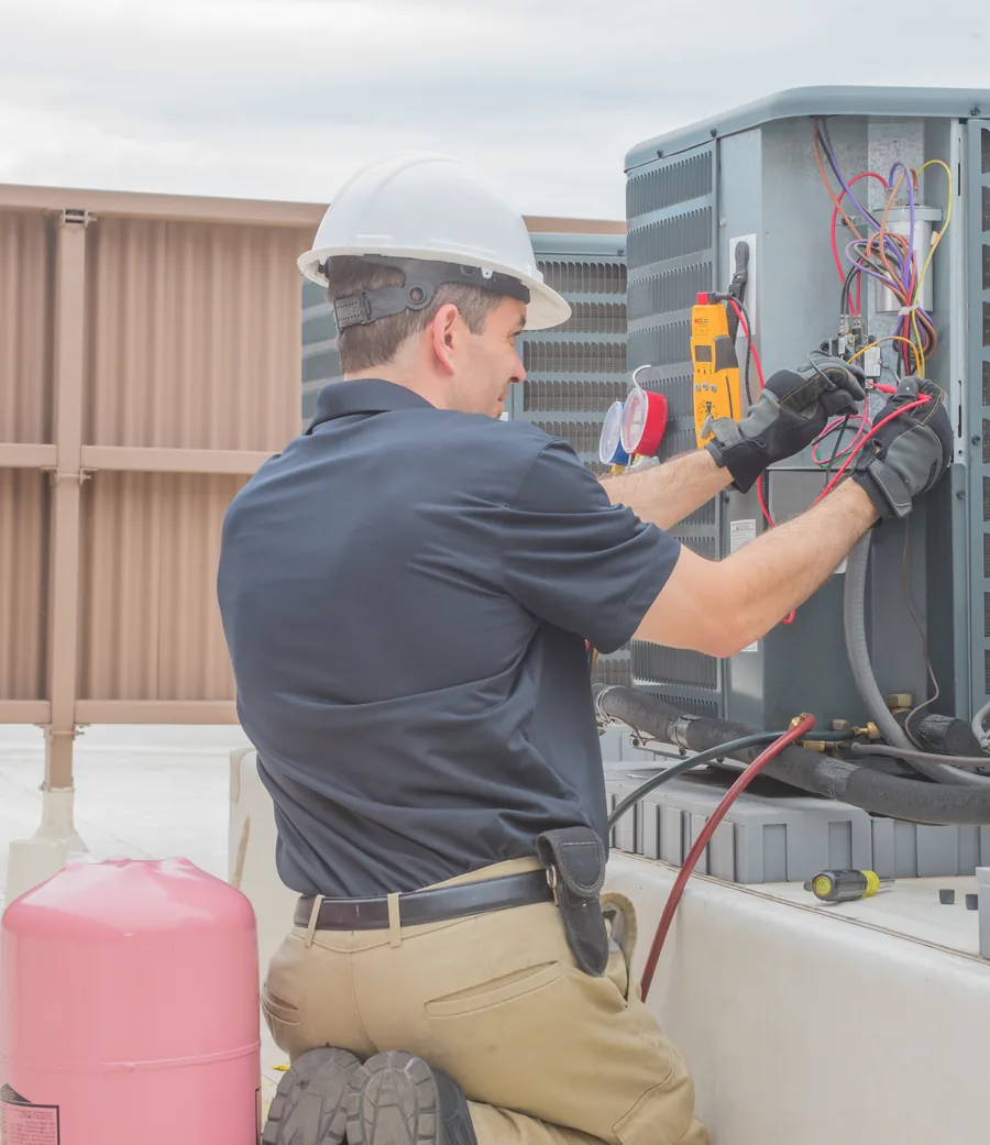 HVAC technician testing an outdoor condensing unit