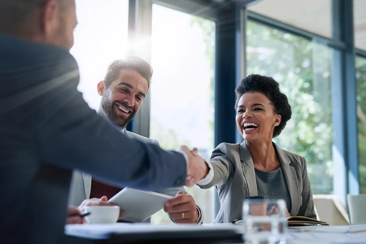 A handshake across a table at a consultation meeting