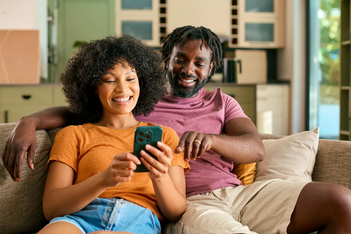 Couple at home on their sofa booking an in-home fireplace consultation