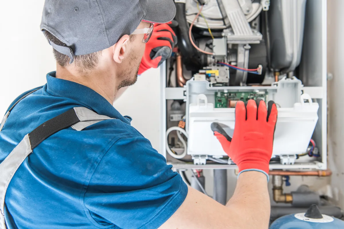 Technician working inside a high-efficiency furnace cabinet