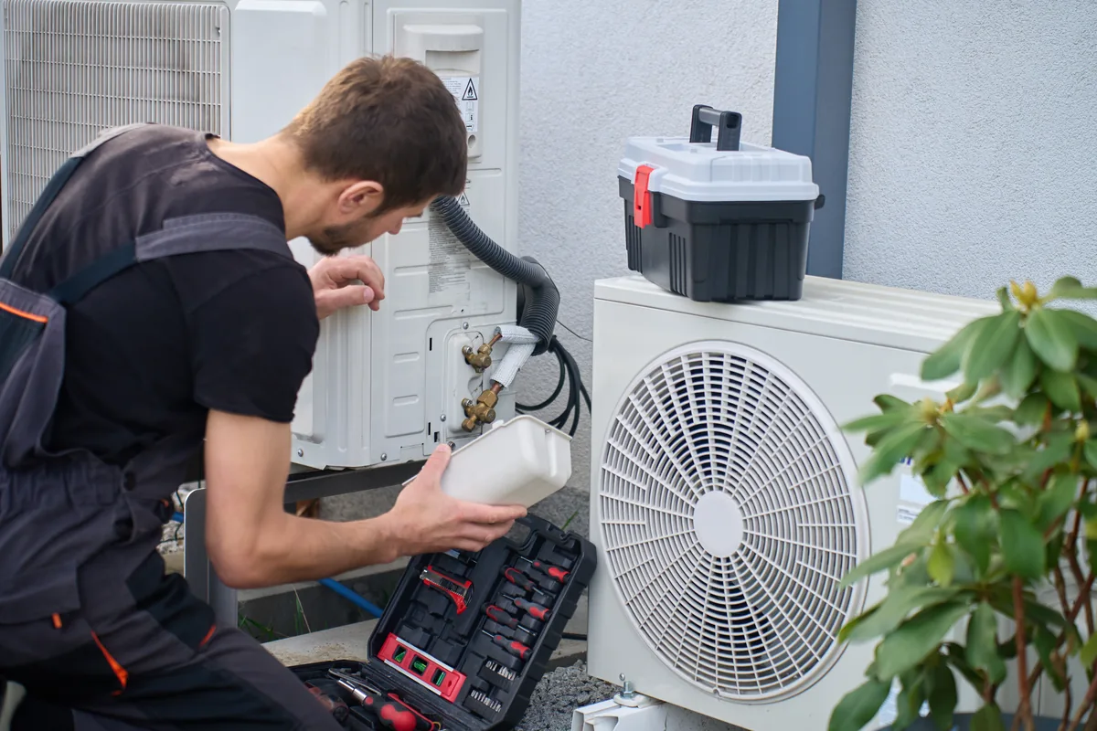 Technician servicing an outdoor unit at a manufactured home