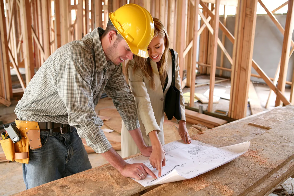 Two tradespeople reviewing plans on a construction site