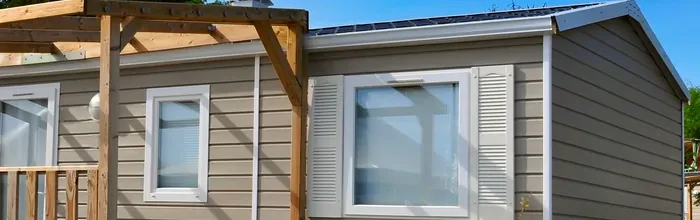 Exterior of a modular home with vinyl siding and a covered deck